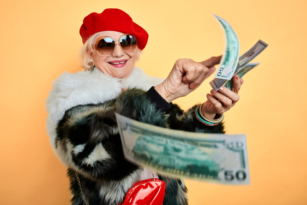 Rich old woman throwing money around